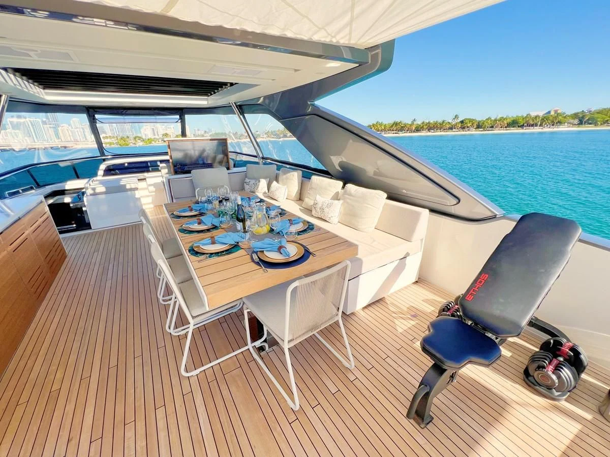 a large white table with chairs on it next to a body of water aboard C-DAZE Yacht for Sale
