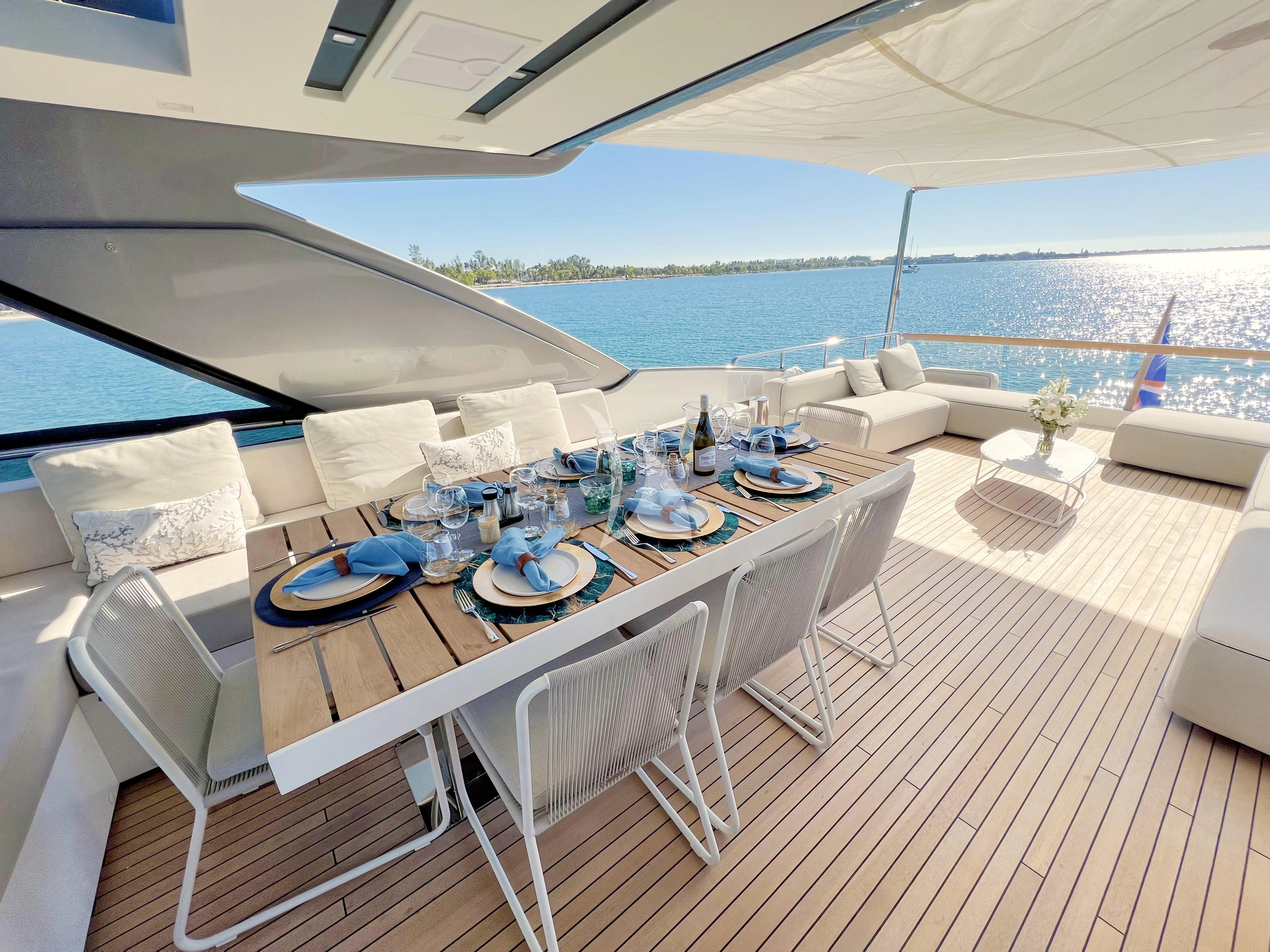 a table set for a meal on a balcony overlooking the ocean aboard C-DAZE Yacht for Sale