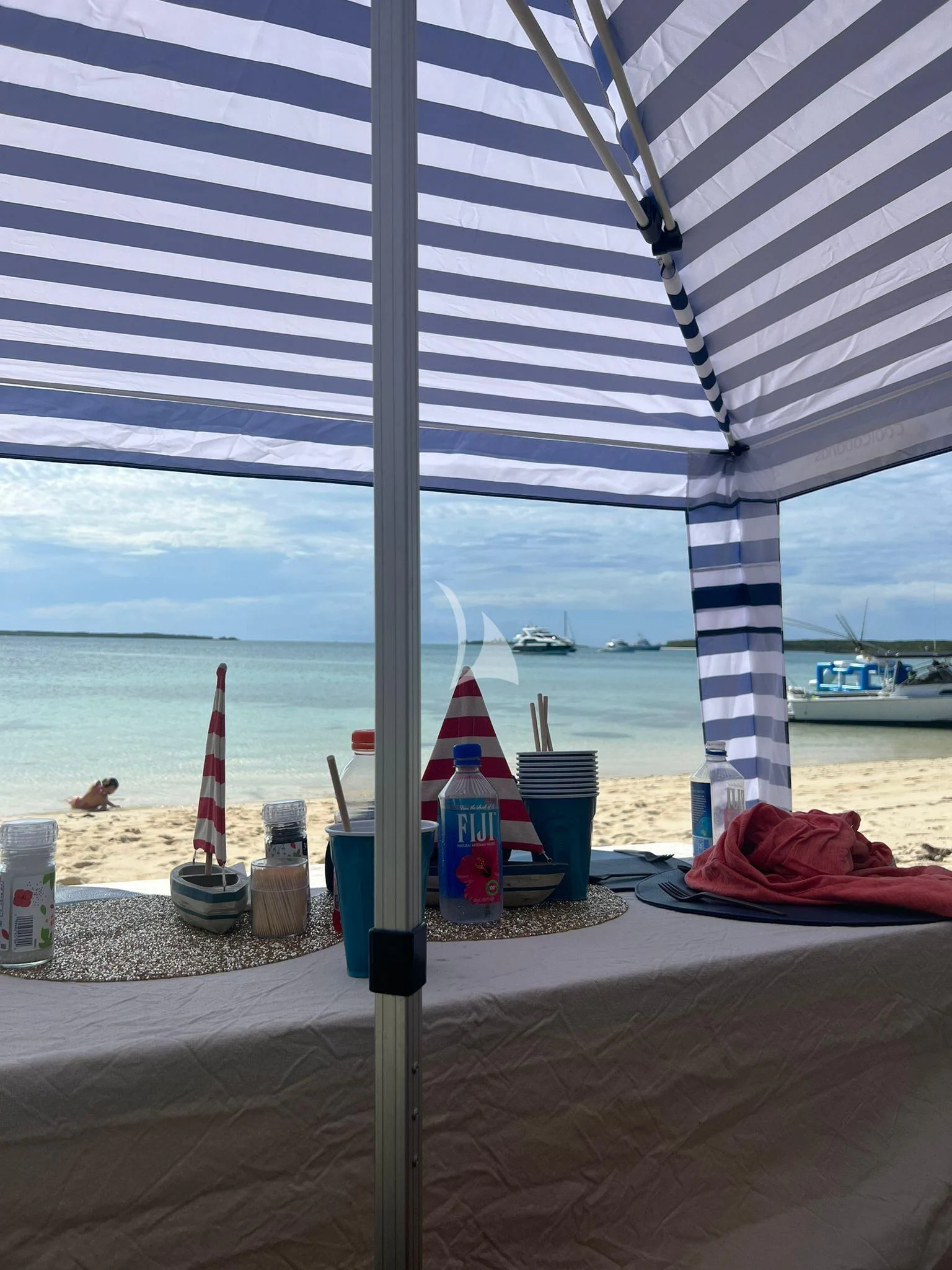 a beach with a large umbrella aboard C-DAZE Yacht for Sale