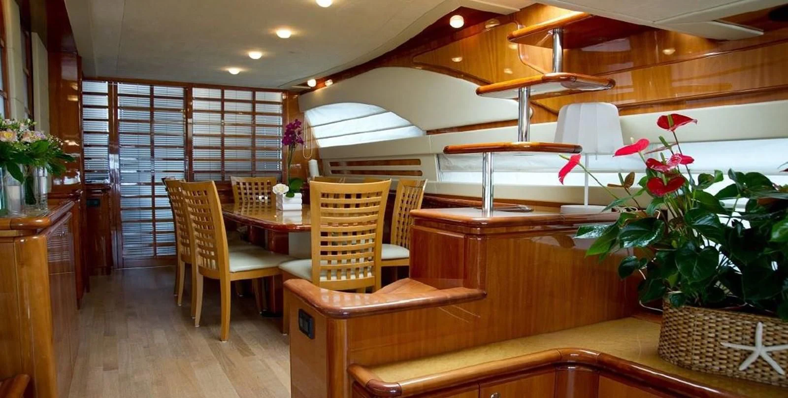 a room with a table chairs and plants aboard PAMPERO Yacht for Charter
