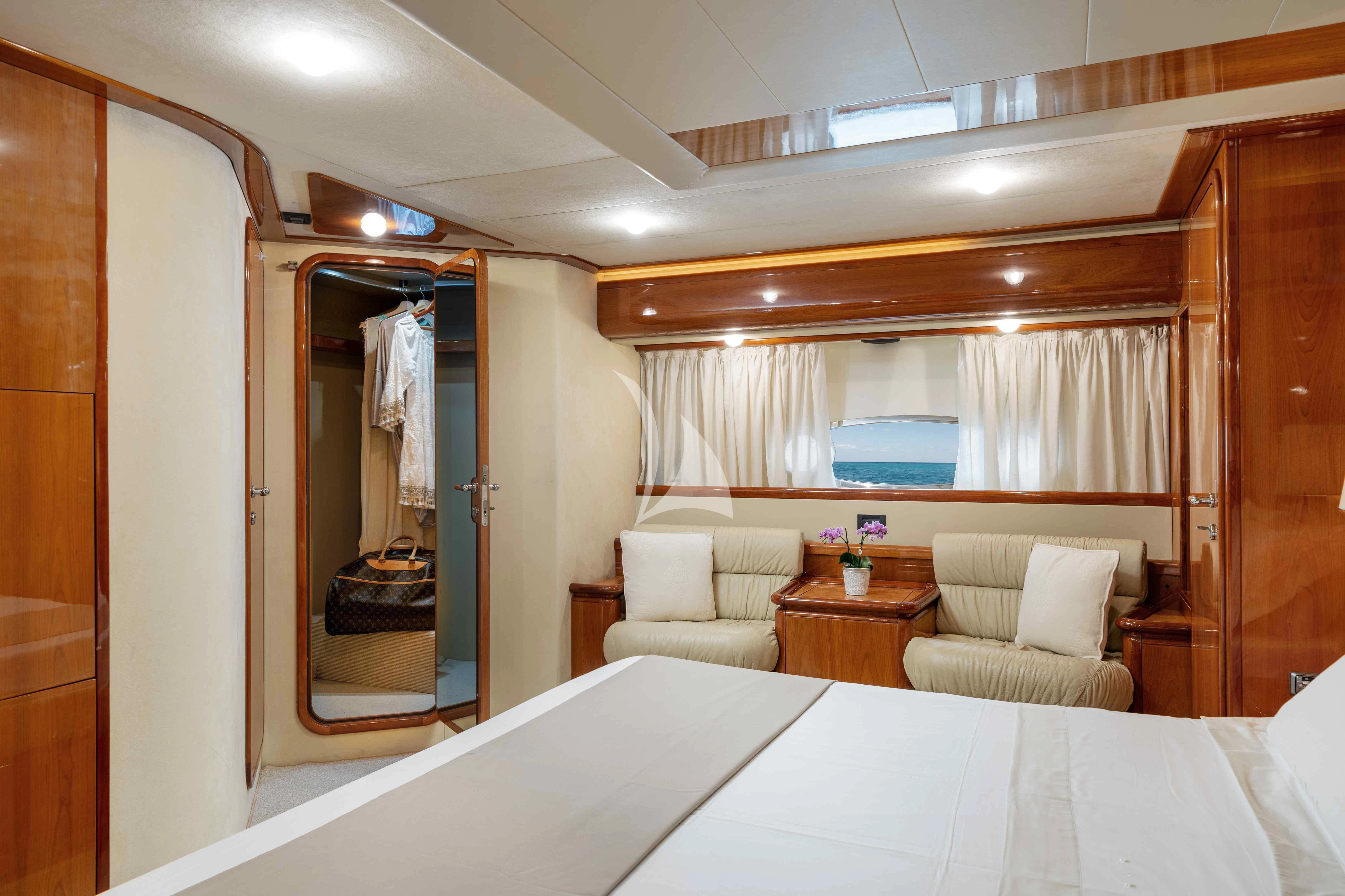 a room with a bed and a chair aboard PAMPERO Yacht for Charter