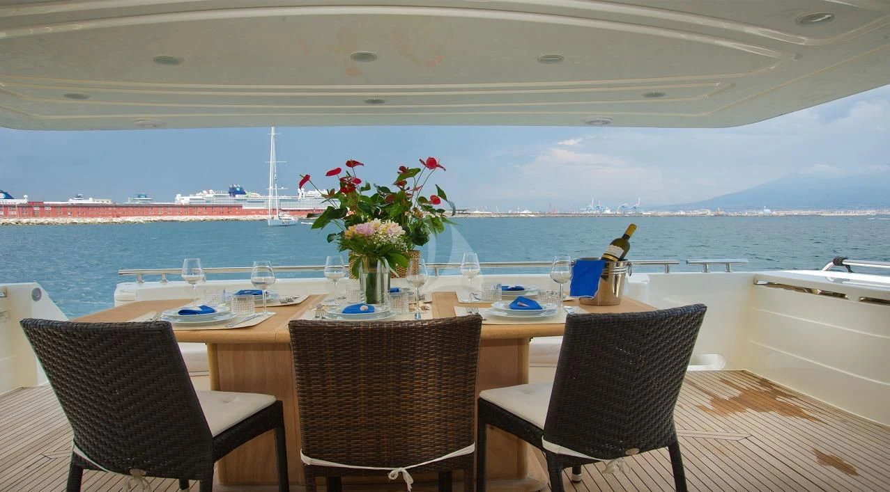 a table with chairs and a vase of flowers on it aboard PAMPERO Yacht for Charter