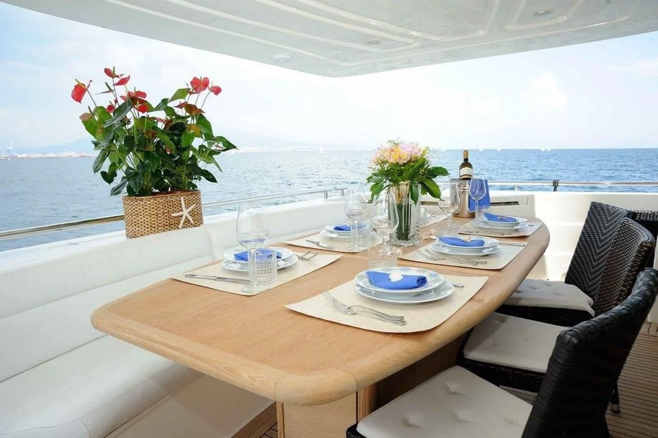 a table with plates and flowers on it aboard PAMPERO Yacht for Charter