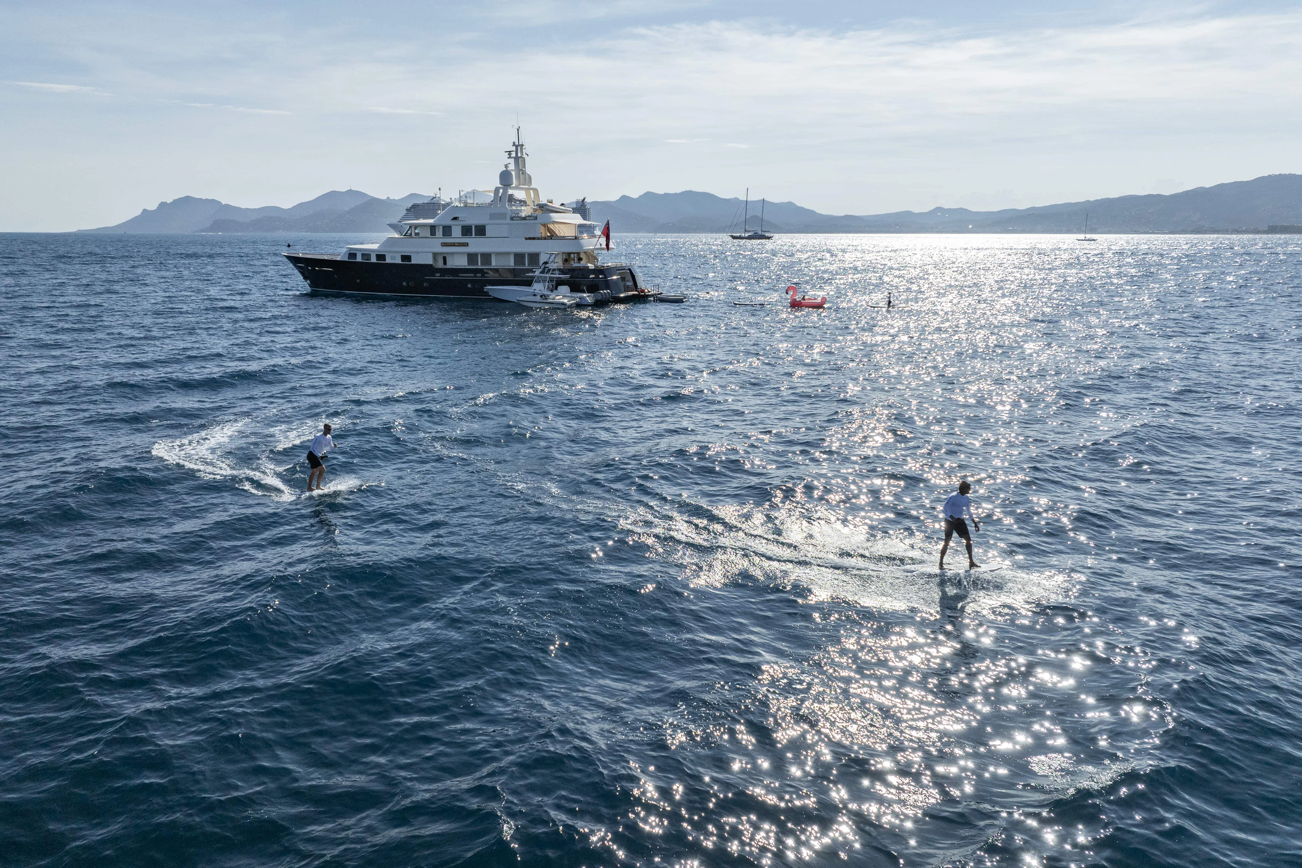 a couple of people surfing in the sea aboard FABULOUS CHARACTER Yacht for Charter