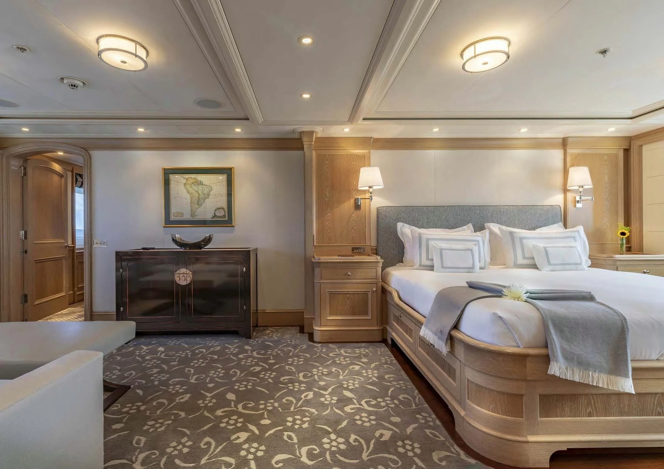 a bedroom with a bed and a dresser aboard FABULOUS CHARACTER Yacht for Charter