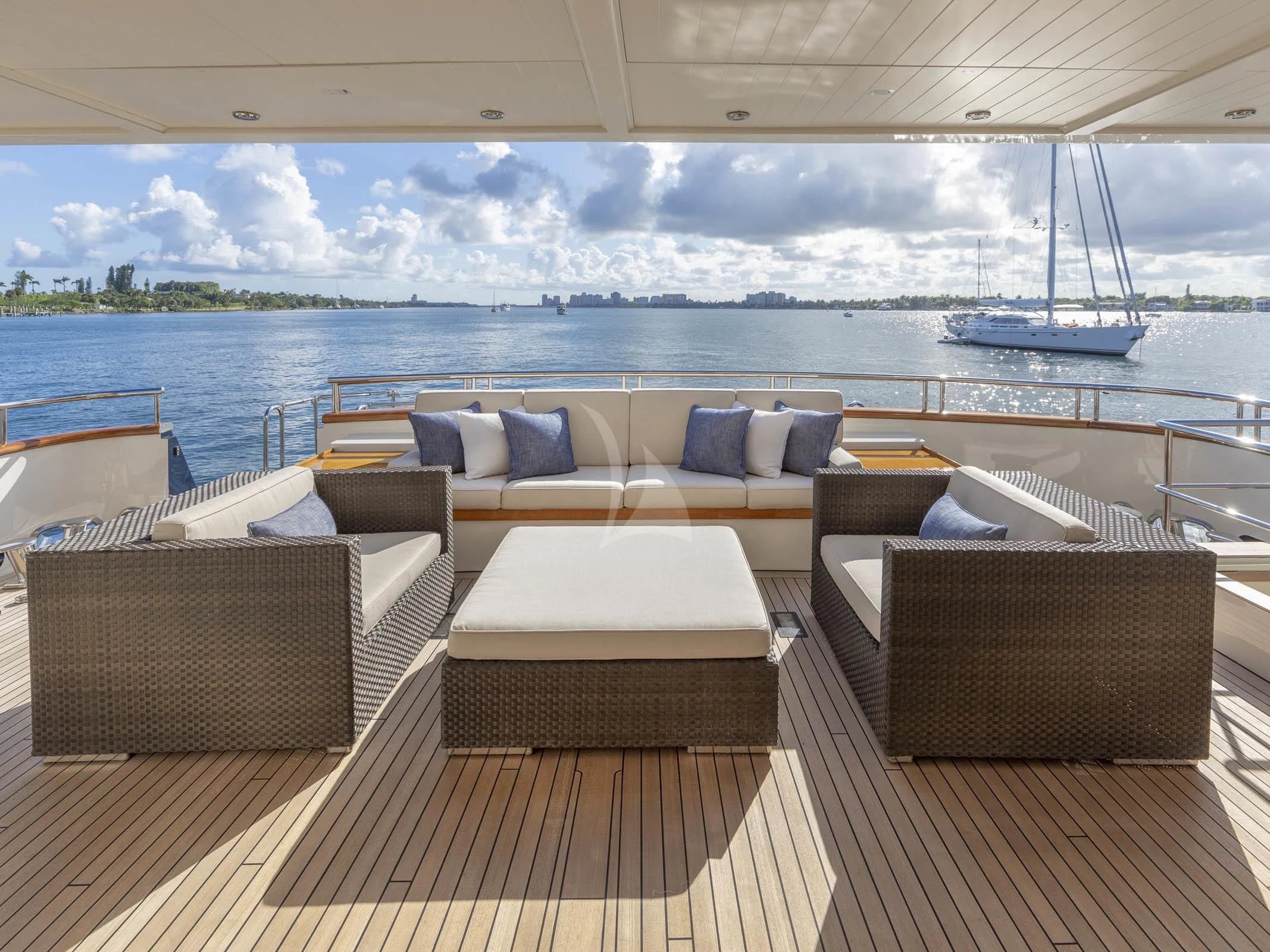 a room with a couch and a table on a deck overlooking a body of water aboard FABULOUS CHARACTER Yacht for Charter