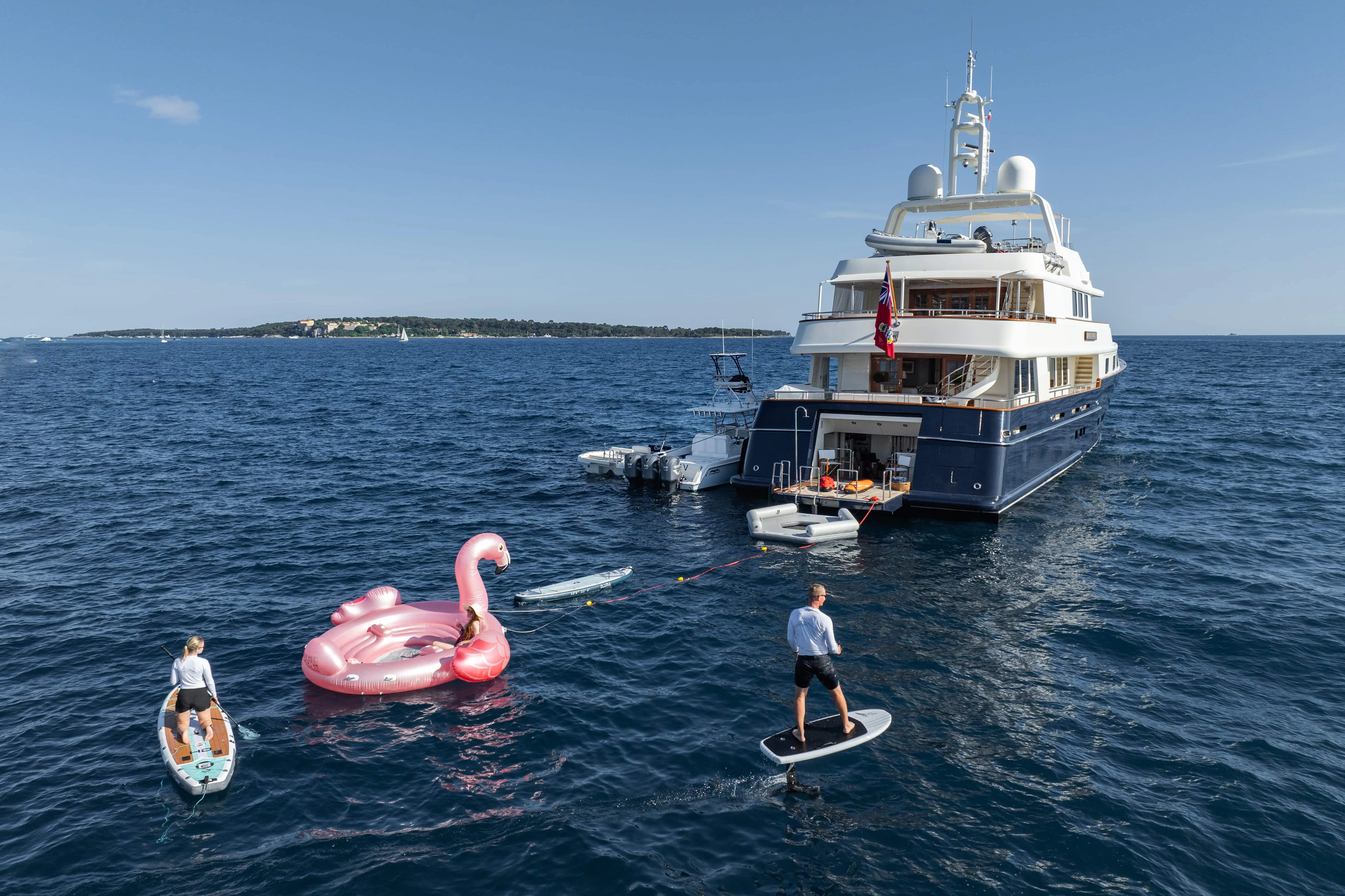 a couple of people on surfboards in the water next to a boat aboard FABULOUS CHARACTER Yacht for Charter