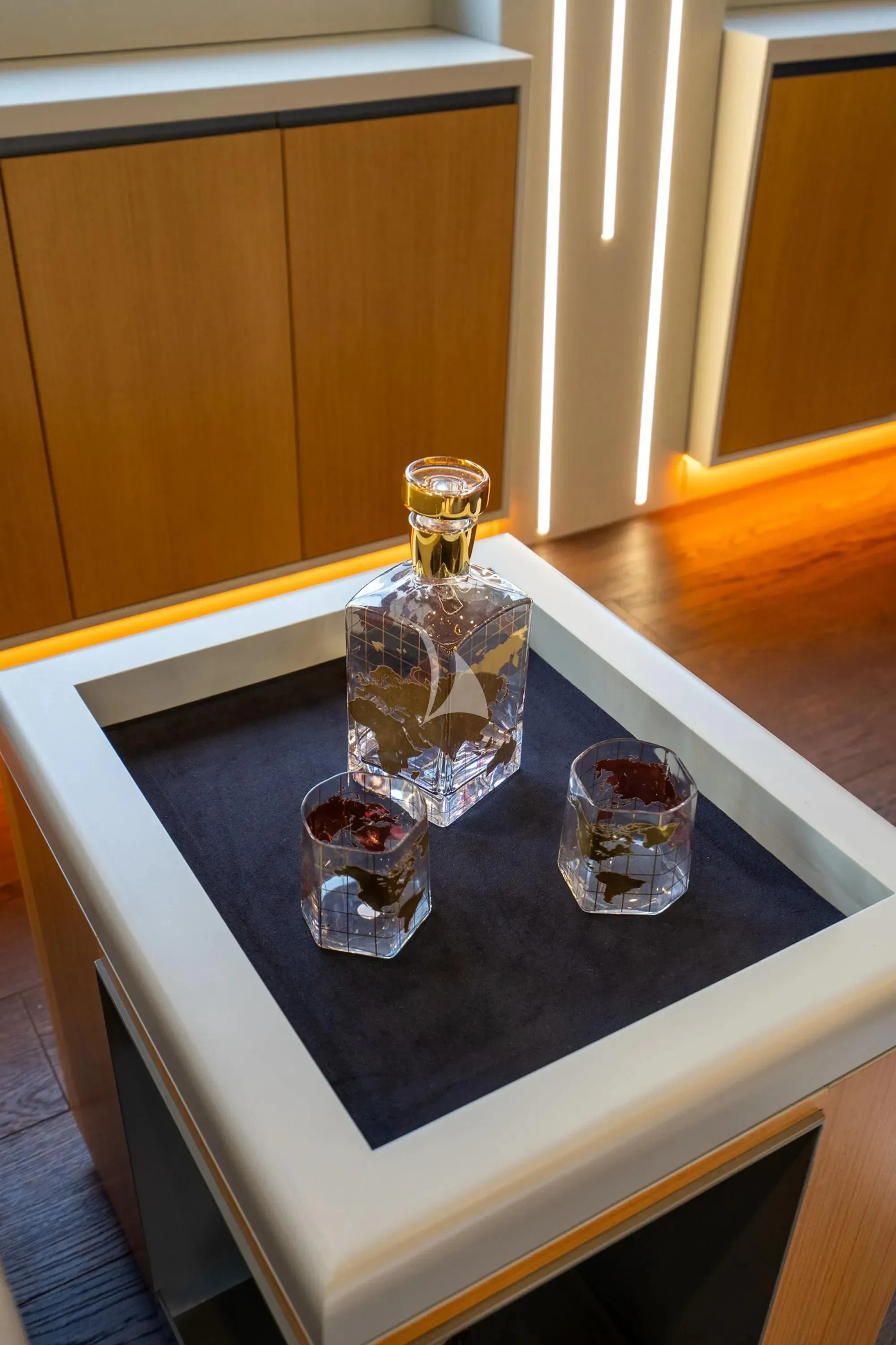 a glass bottle and a glass on a table aboard NORTH WIND Yacht for Sale