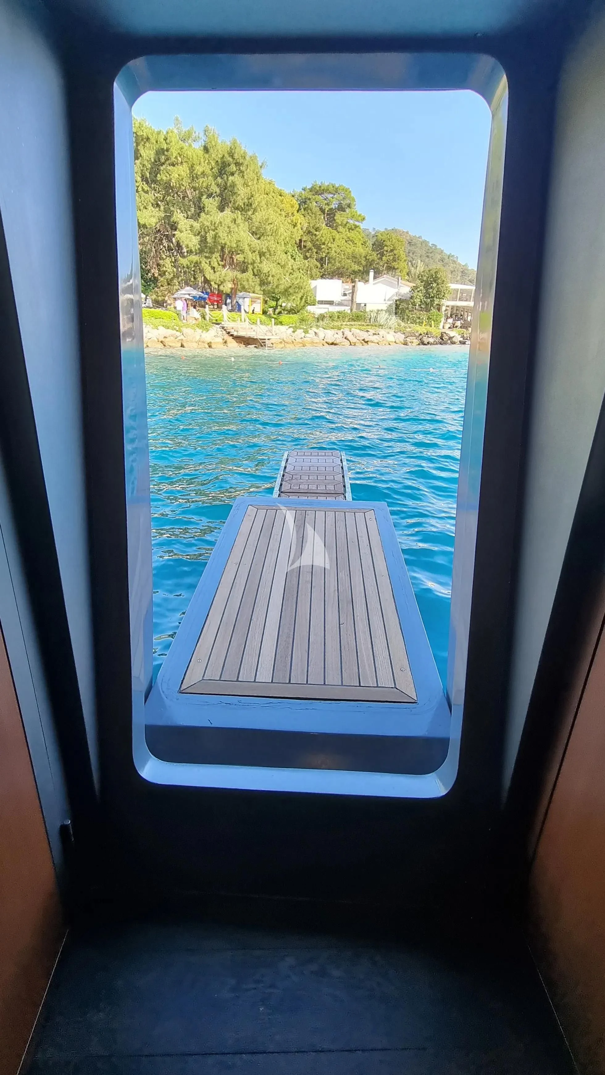 a window with a view of the water and trees aboard NORTH WIND Yacht for Sale