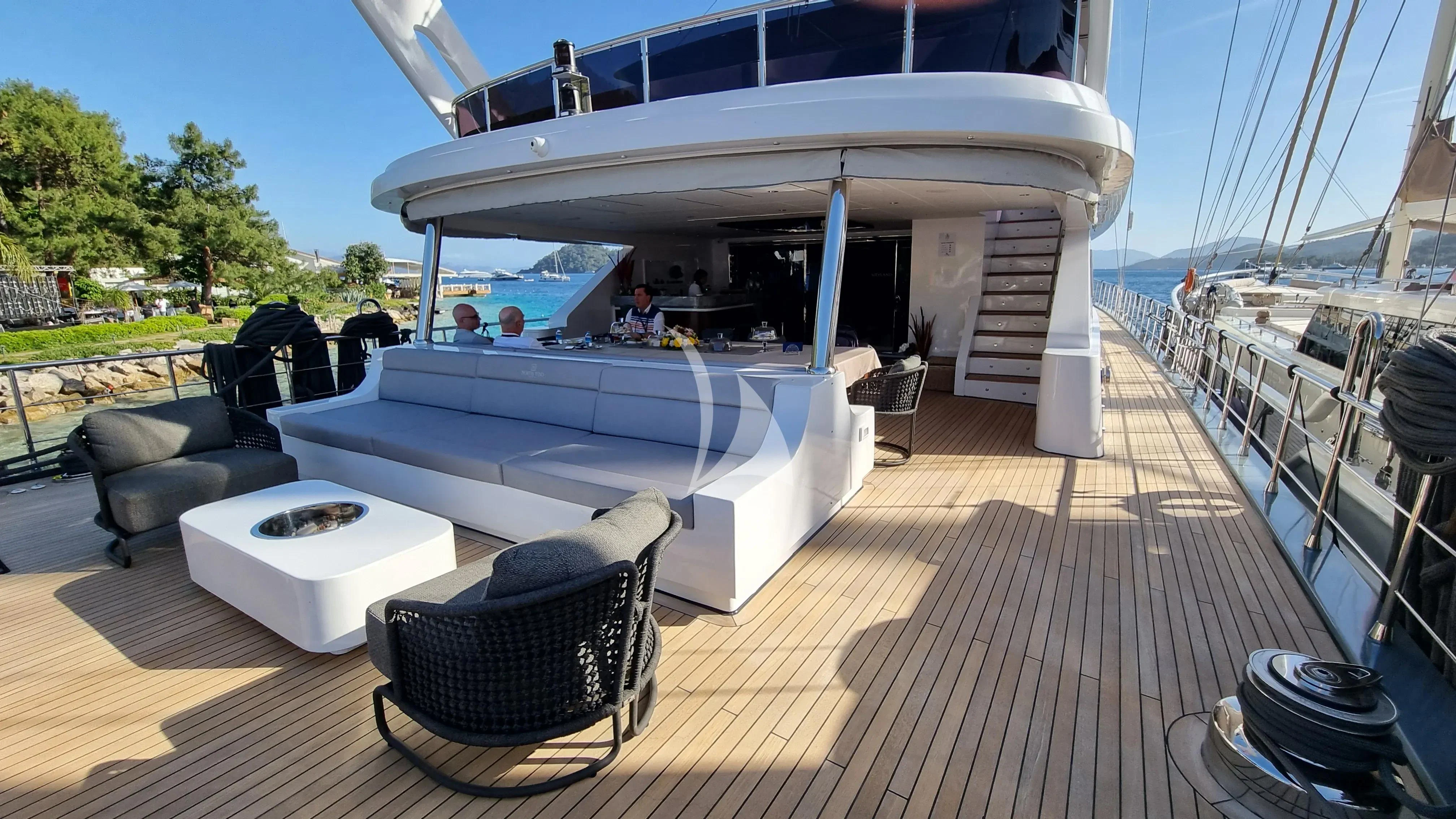 a deck with a pool and a deck with chairs and a table aboard NORTH WIND Yacht for Sale