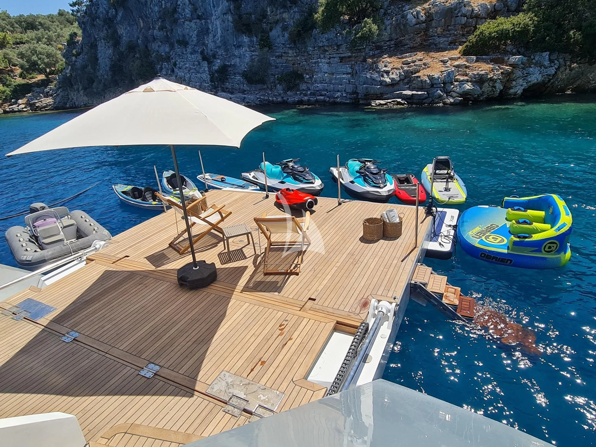a beach with boats and umbrellas aboard NORTH WIND Yacht for Sale
