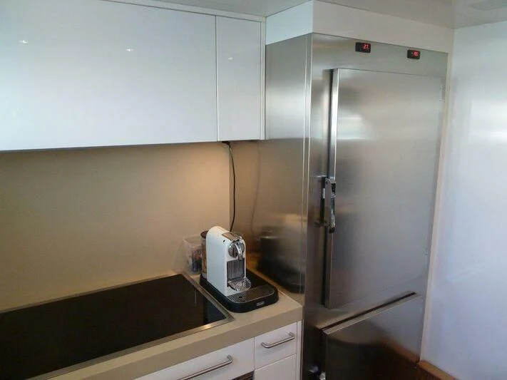 a kitchen with a stainless steel refrigerator aboard TYAMO Yacht for Sale