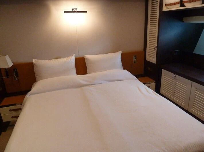 a bed with white sheets aboard TYAMO Yacht for Sale