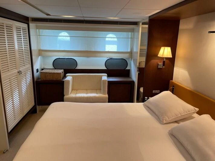 a bed with a white bed and a desk in a room aboard TYAMO Yacht for Sale