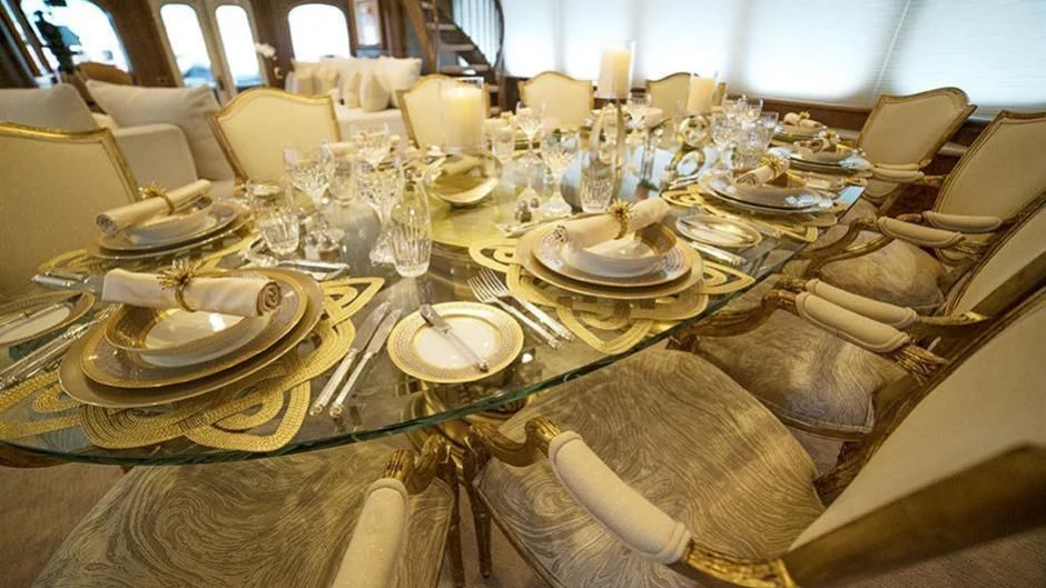 a table set with plates and chairs aboard GRAND ILLUSION Yacht for Sale