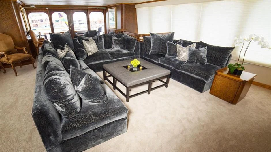 a living room with a black couch and a coffee table aboard GRAND ILLUSION Yacht for Sale