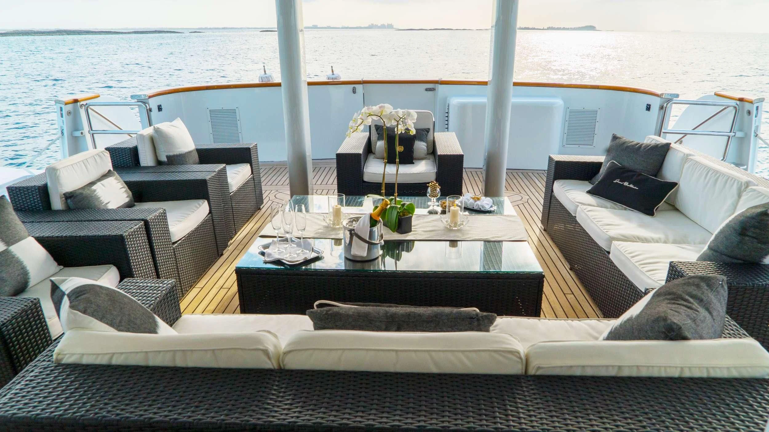 a table with chairs and a couch on a boat in the water aboard GRAND ILLUSION Yacht for Sale