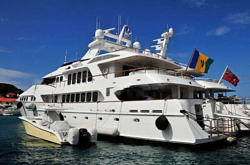 a large white boat with a flag on it aboard GRAND ILLUSION Yacht for Sale