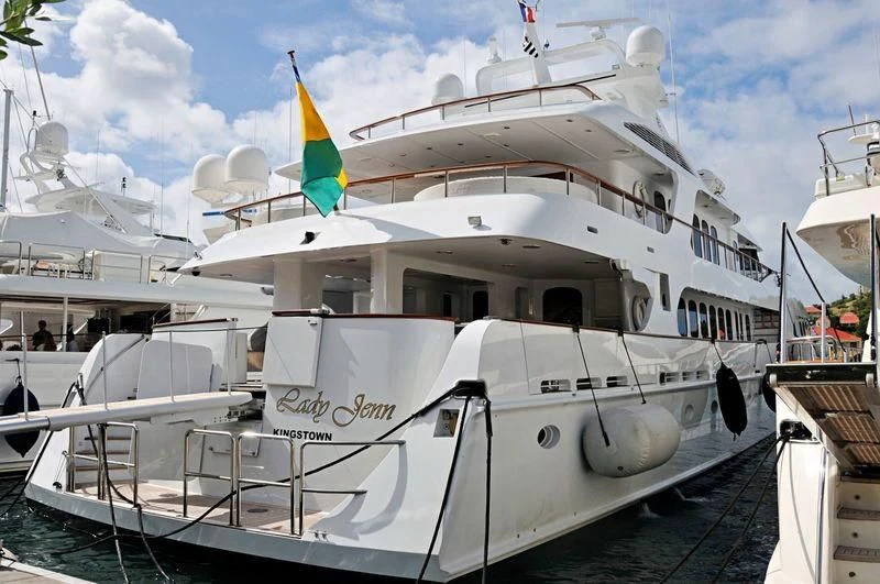 a white boat with flags on it aboard GRAND ILLUSION Yacht for Sale