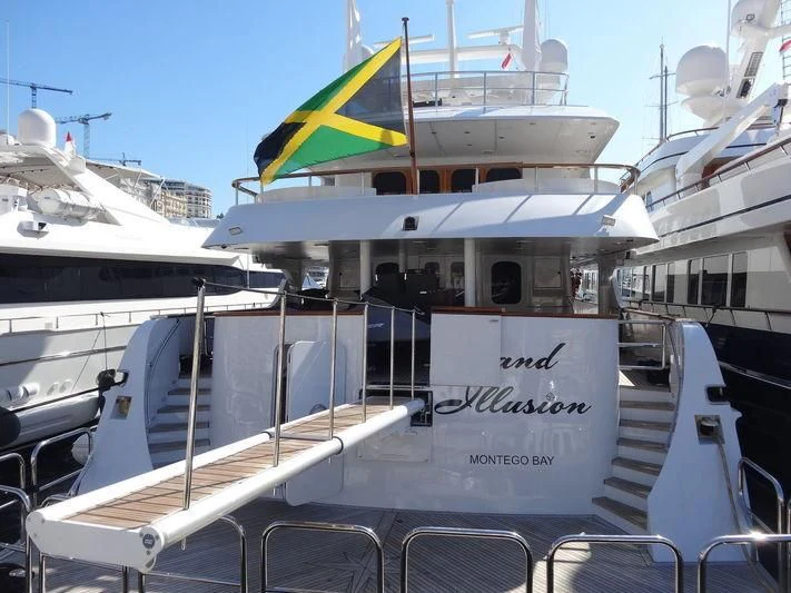 a boat with a flag on the deck aboard GRAND ILLUSION Yacht for Sale