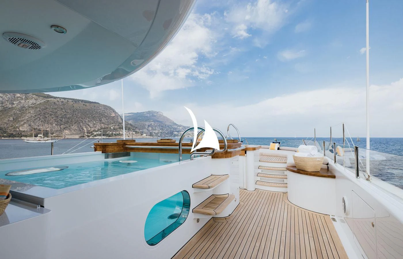 a pool with a deck and a view of mountains and water aboard VENTUM MARIS Yacht for Charter