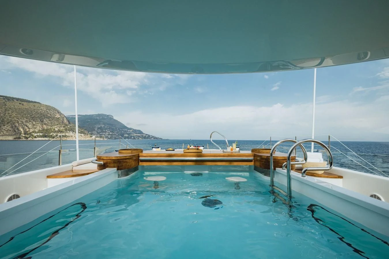 a pool with a view of mountains and water aboard VENTUM MARIS Yacht for Charter