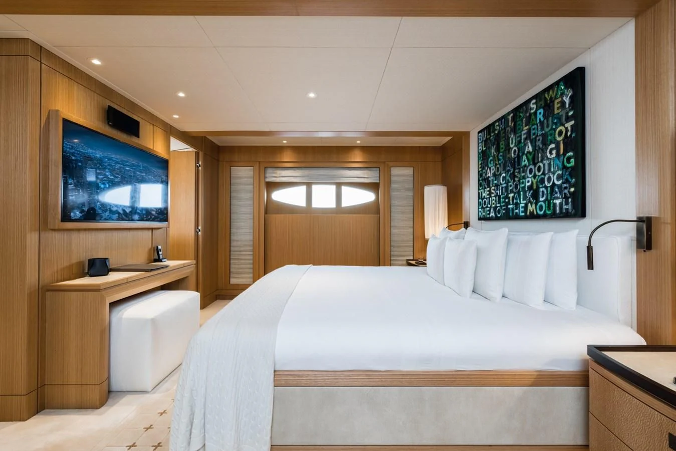 a bedroom with a bed and a tv on the wall aboard VENTUM MARIS Yacht for Charter