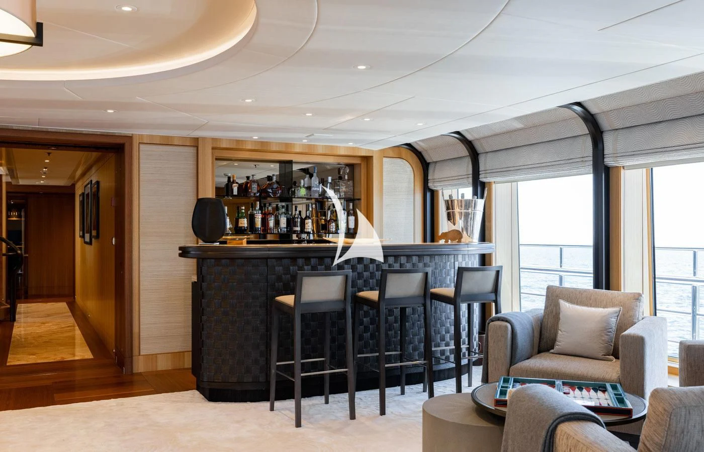 a living room with a bar and chairs aboard VENTUM MARIS Yacht for Charter