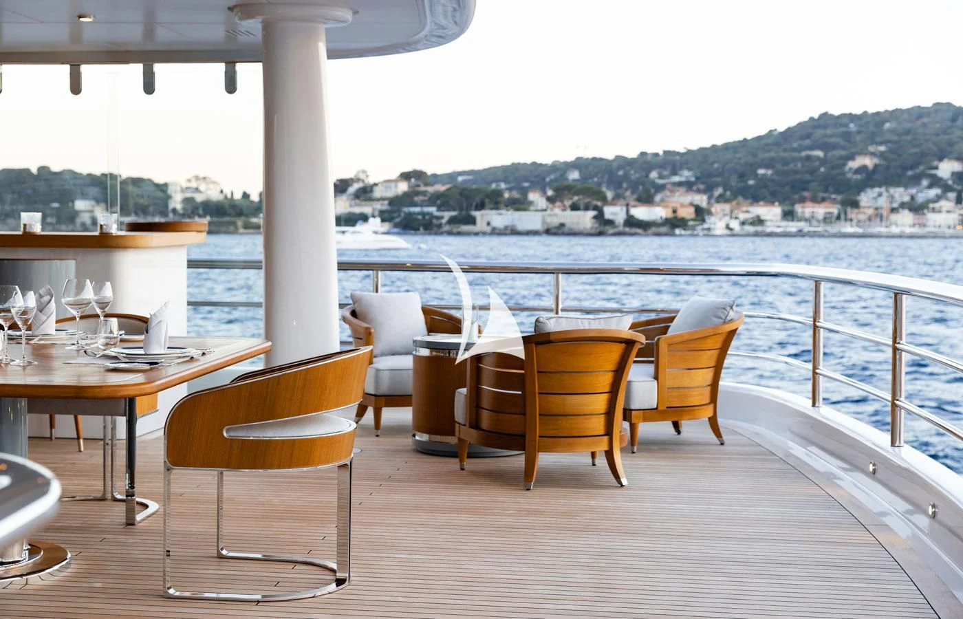 a table and chairs on a balcony overlooking a body of water aboard VENTUM MARIS Yacht for Charter