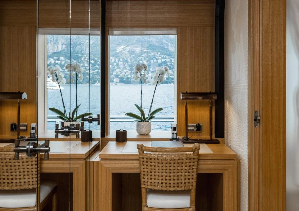 a room with a window and a chair and a table with plants aboard VENTUM MARIS Yacht for Charter