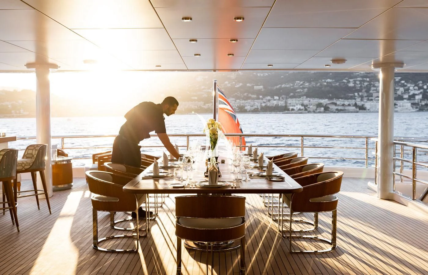 a person sitting at a table on a deck overlooking the ocean aboard VENTUM MARIS Yacht for Charter