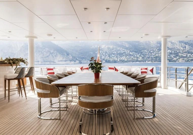a table with chairs and a view of a city aboard VENTUM MARIS Yacht for Charter
