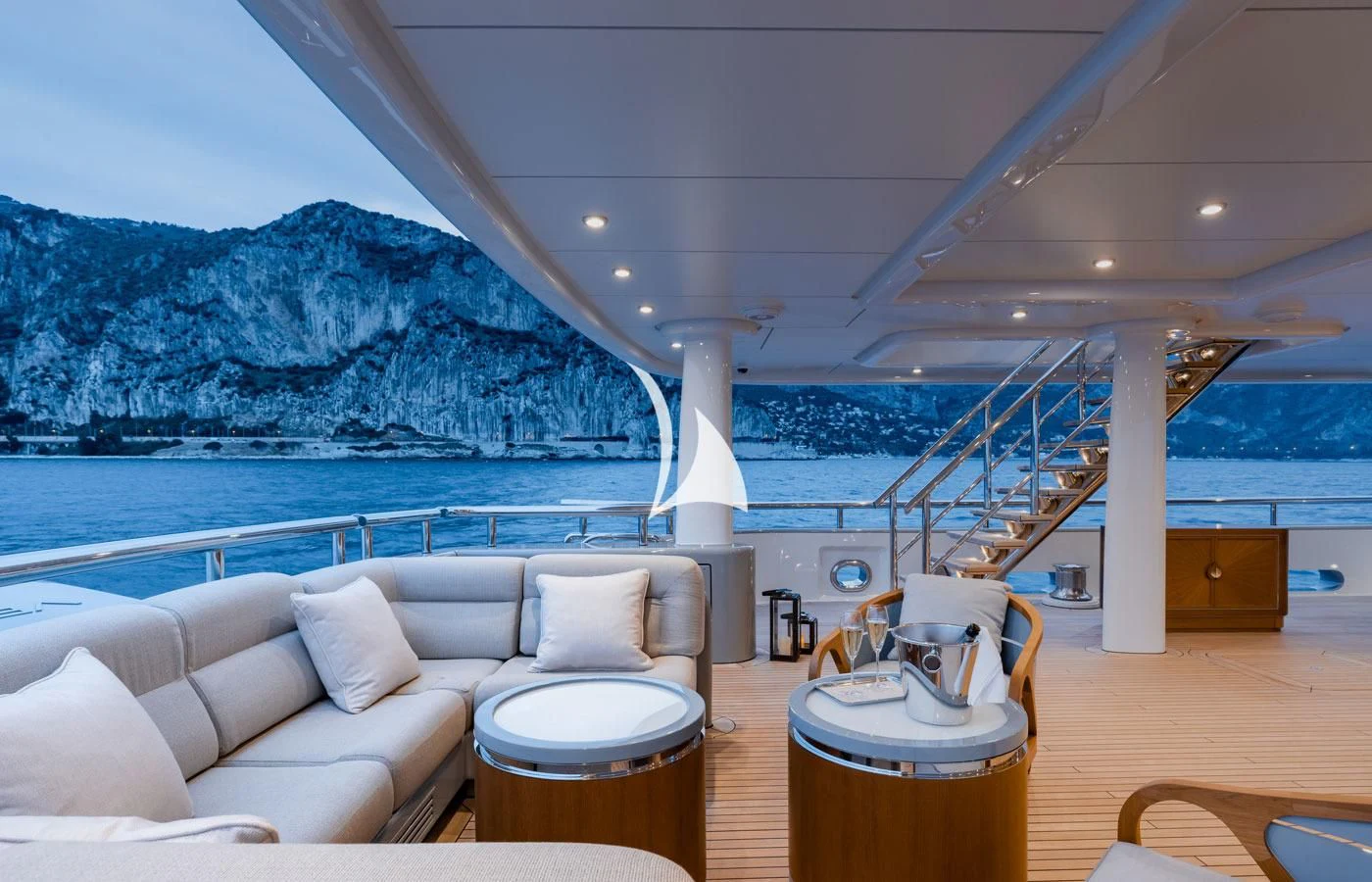 a living room with a large body of water and mountains in the background aboard VENTUM MARIS Yacht for Charter