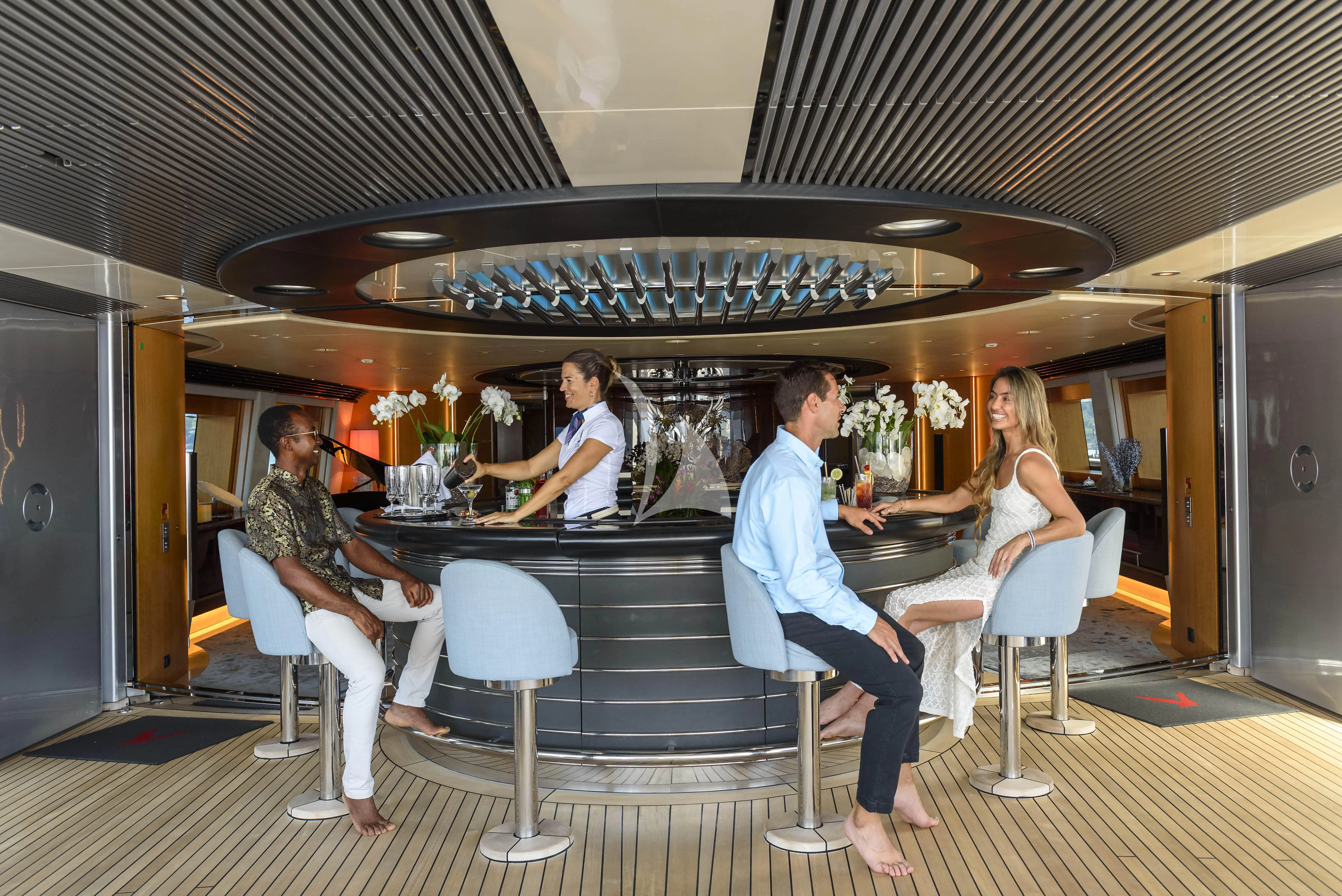 a group of people sitting around a table aboard MALTESE FALCON Yacht for Sale