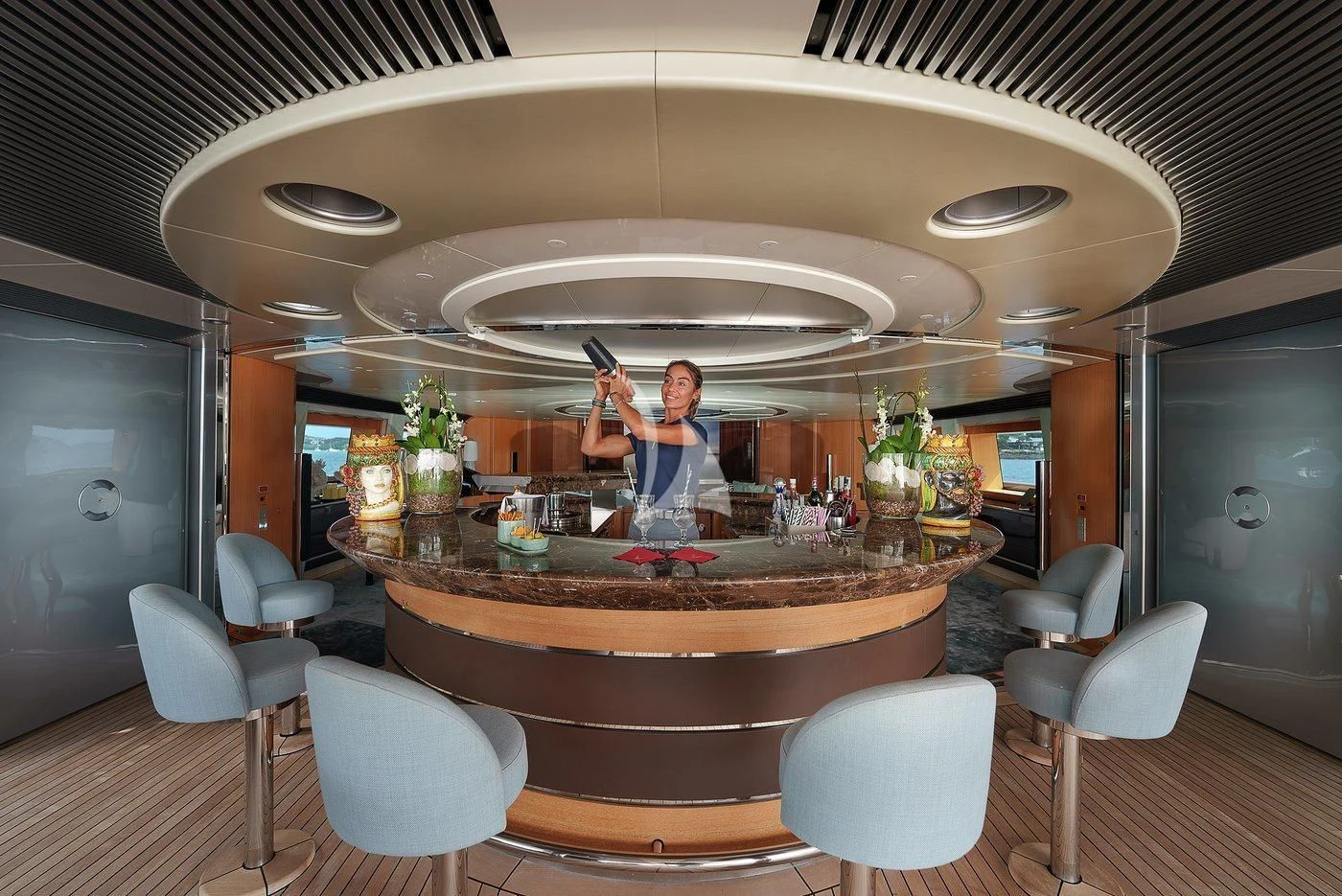 a couple of men standing in a large round table with chairs and a large round glass display with aboard MALTESE FALCON Yacht for Sale