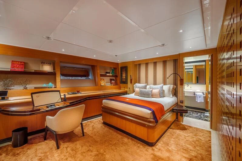 a bedroom with a bed and desk aboard MALTESE FALCON Yacht for Sale