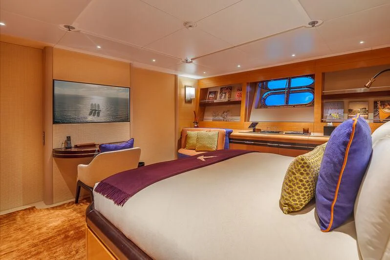 a bedroom with a bed and a tv on the wall aboard MALTESE FALCON Yacht for Sale