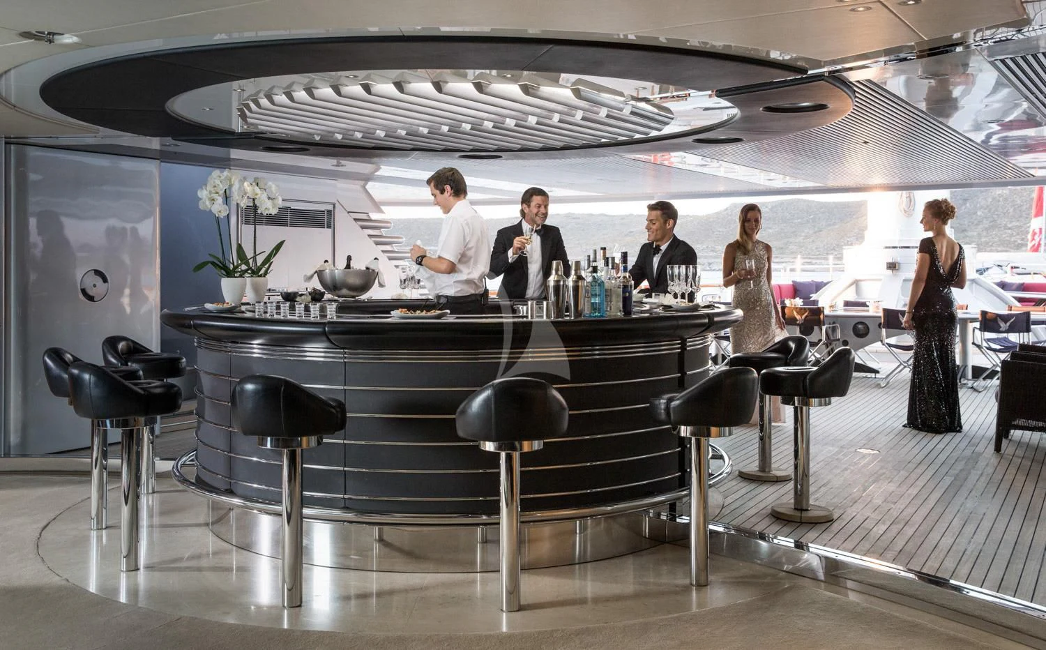 a group of people sitting around a bar aboard MALTESE FALCON Yacht for Sale