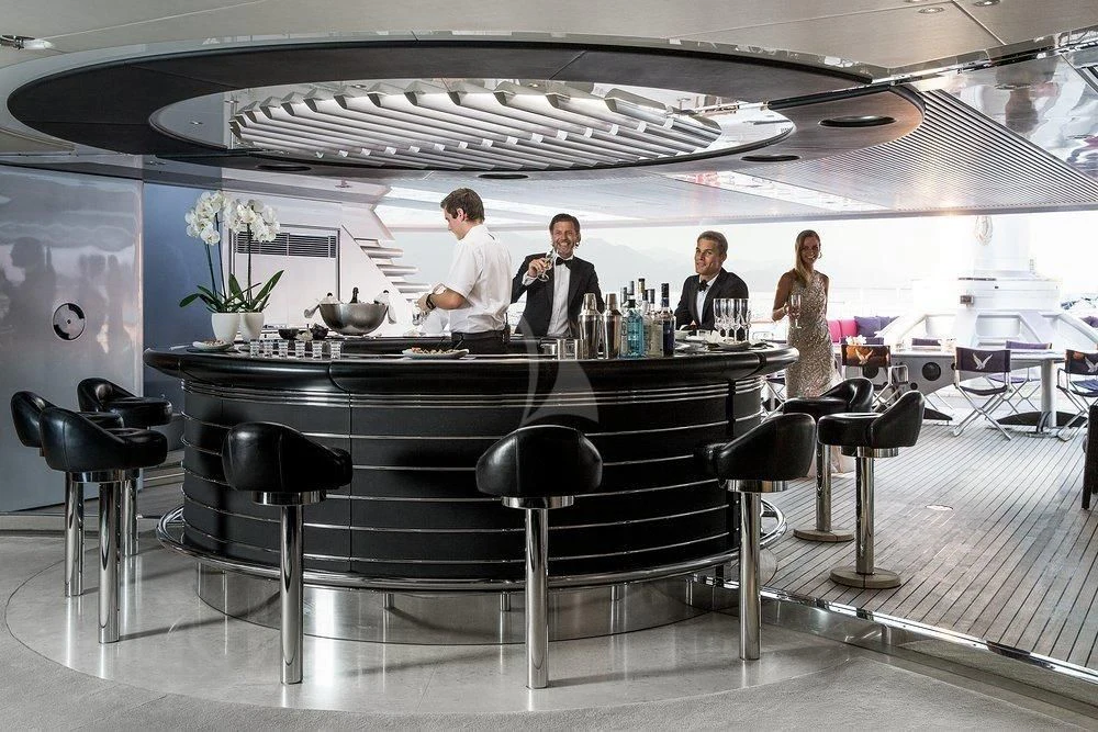 a group of people sitting at a bar aboard MALTESE FALCON Yacht for Sale
