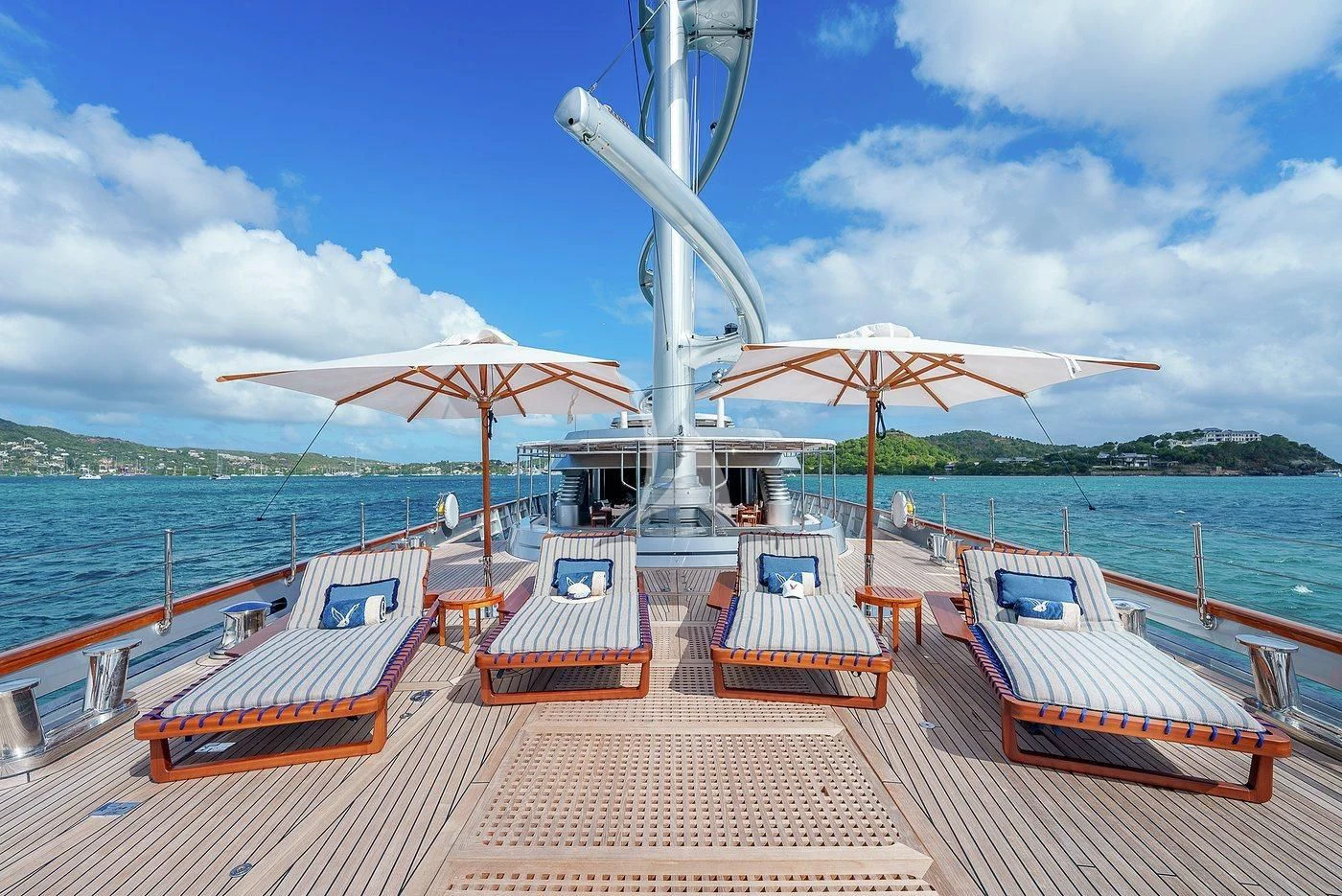 a deck with chairs and umbrellas on it by the water aboard MALTESE FALCON Yacht for Sale