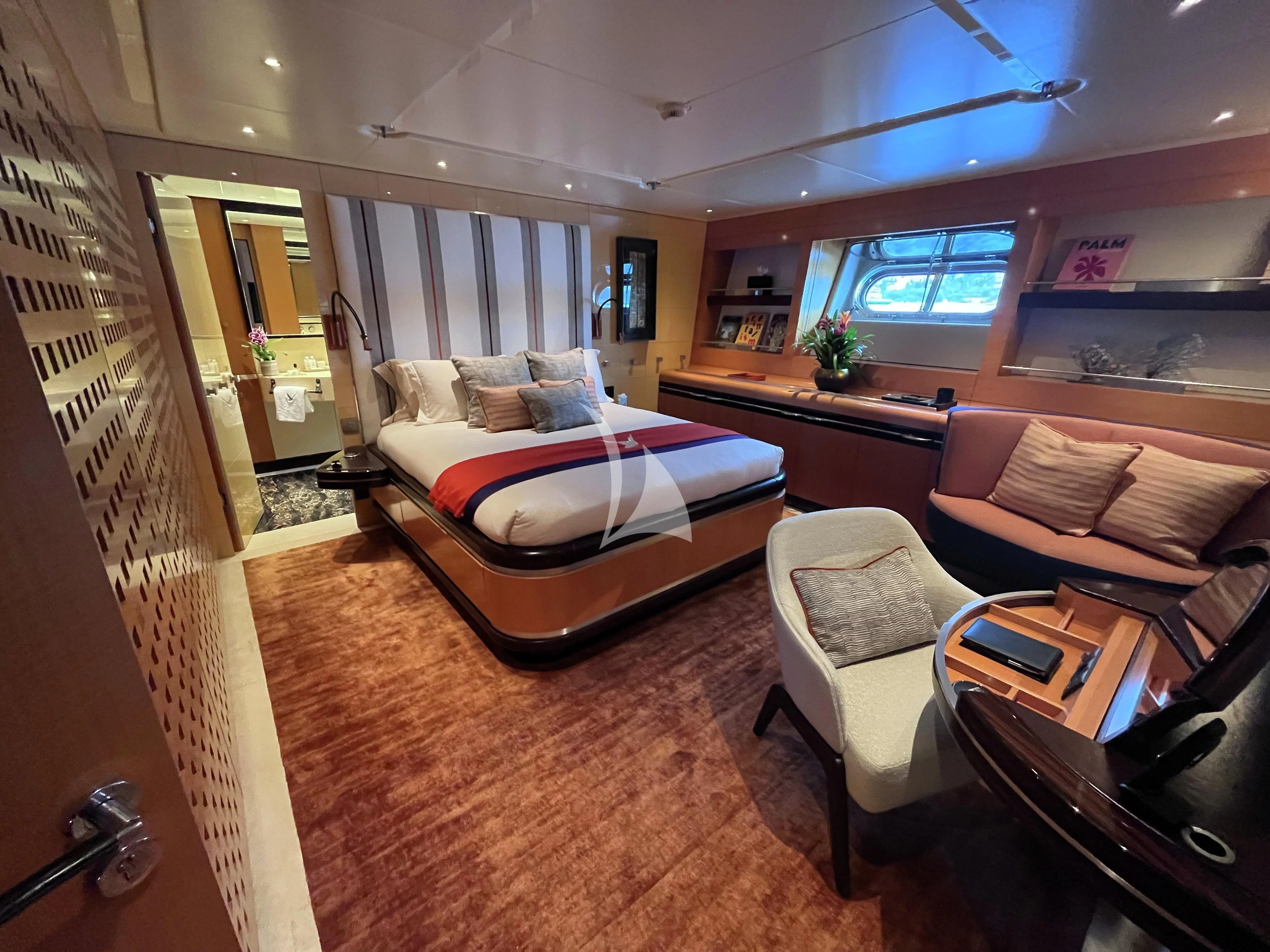 a bedroom with a bed and a desk aboard MALTESE FALCON Yacht for Sale