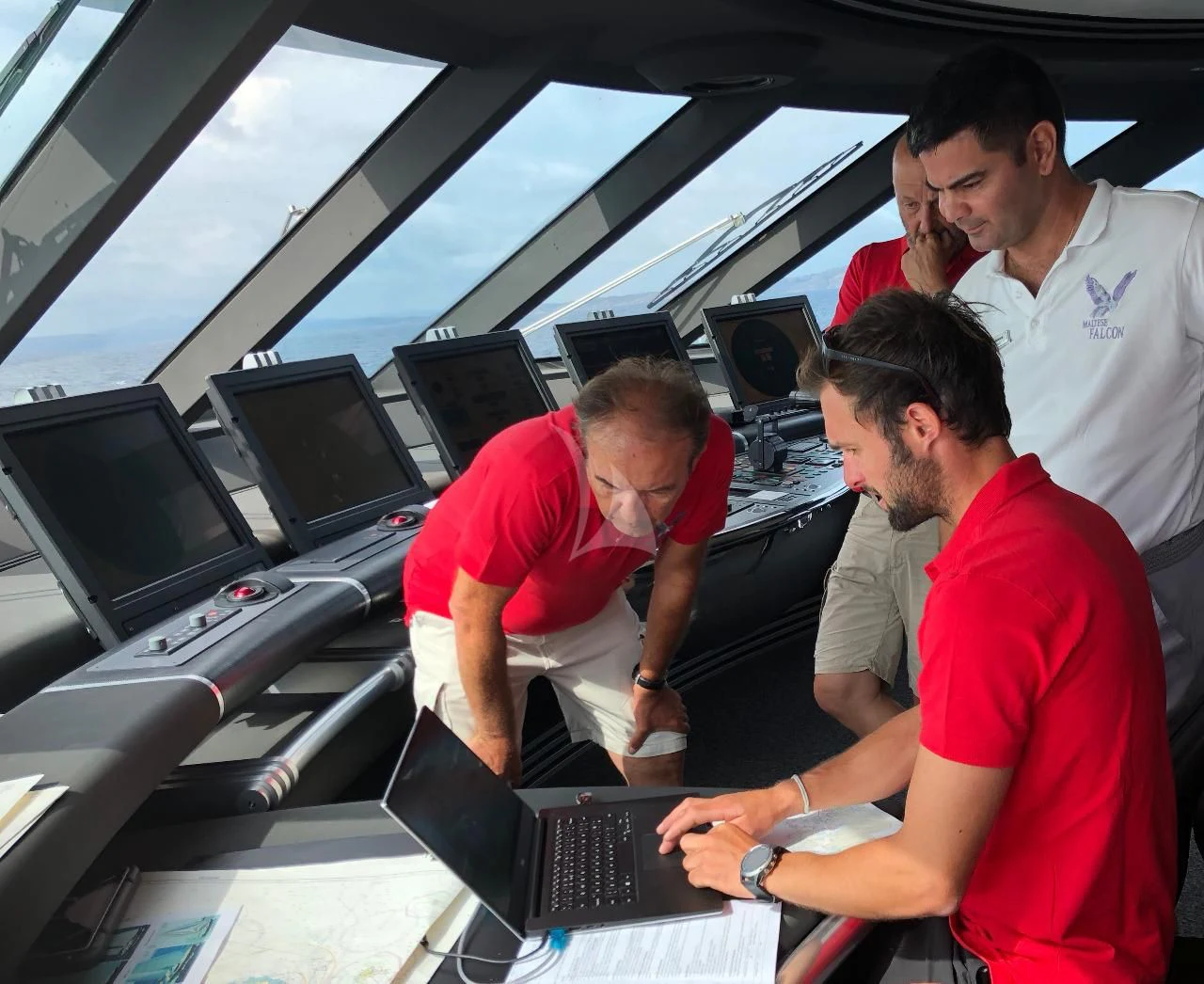 a group of men in a car looking at a computer screen aboard MALTESE FALCON Yacht for Sale