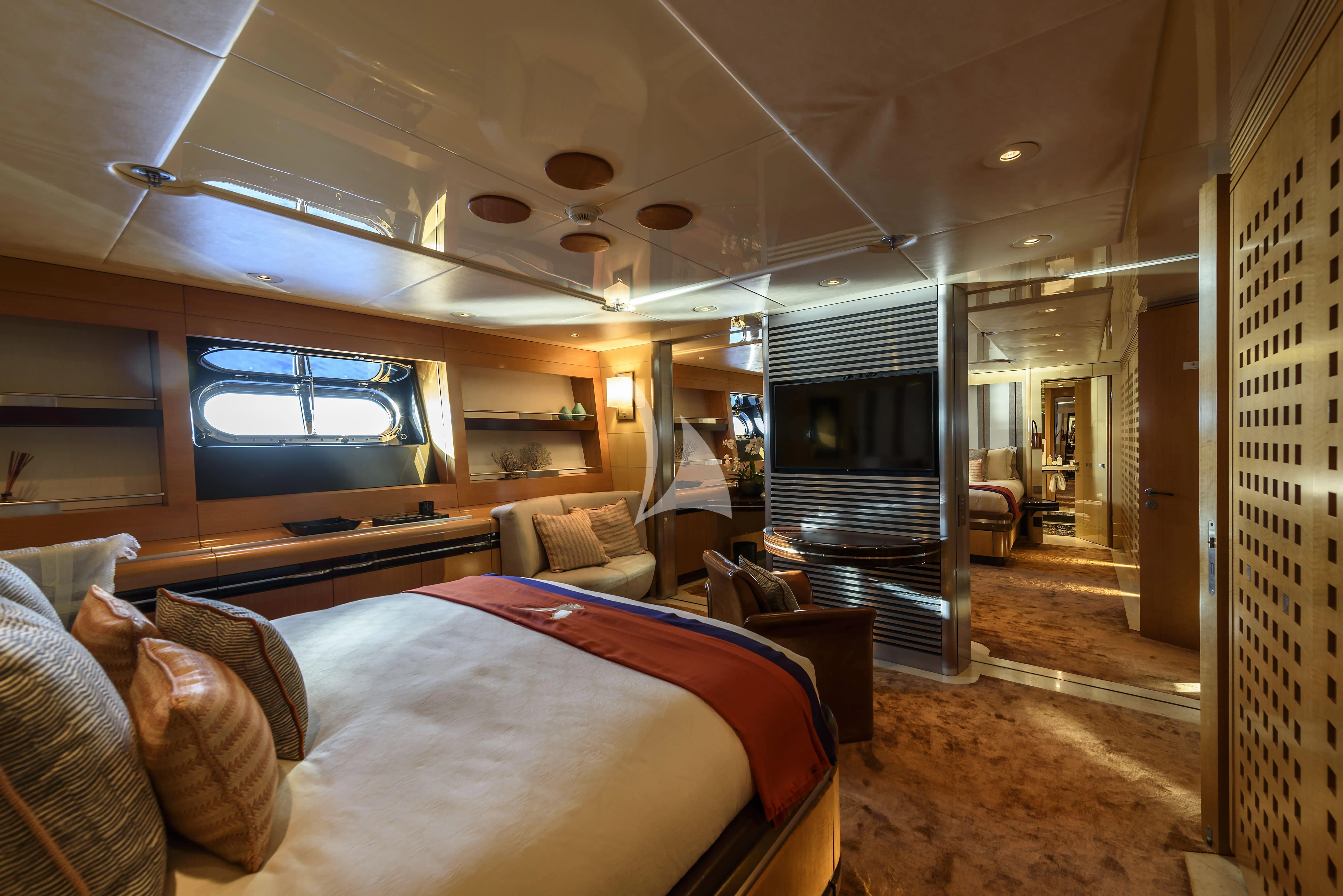 a bedroom with a bed and a fireplace aboard MALTESE FALCON Yacht for Sale
