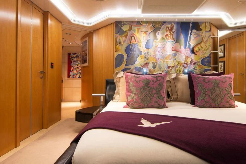 a bed with a painting on the wall aboard MALTESE FALCON Yacht for Sale