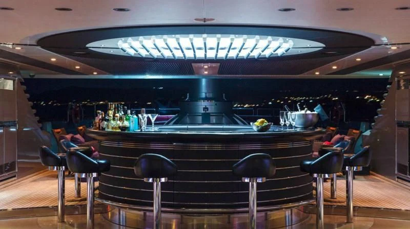 a bar with a large bar and chairs aboard MALTESE FALCON Yacht for Sale