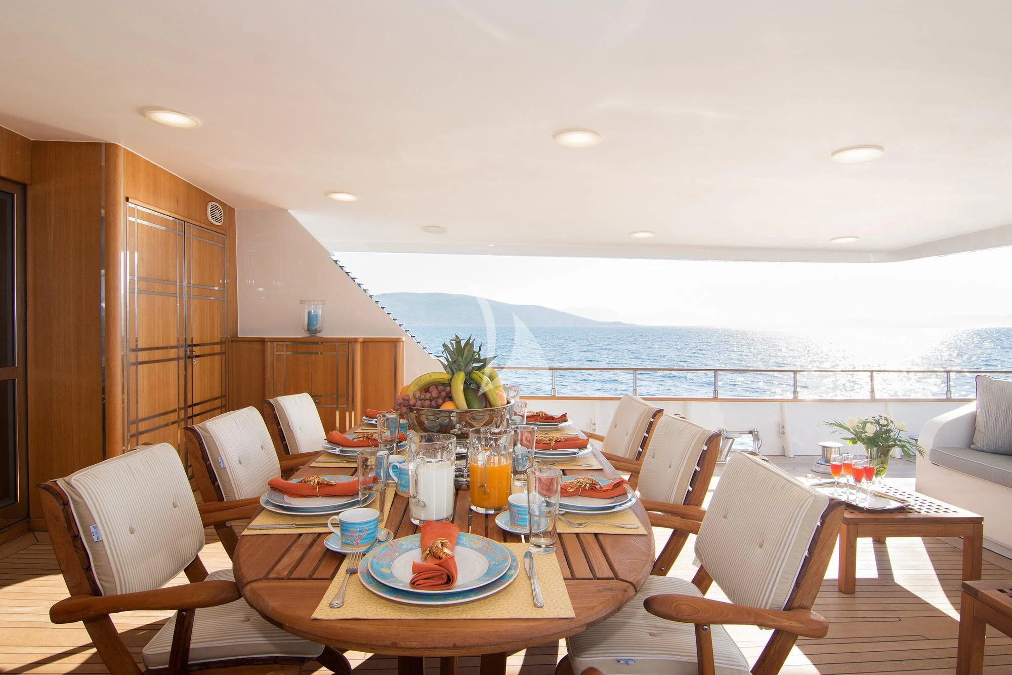 a dining table with chairs and a view of the ocean aboard BELLA STELLA Yacht for Charter