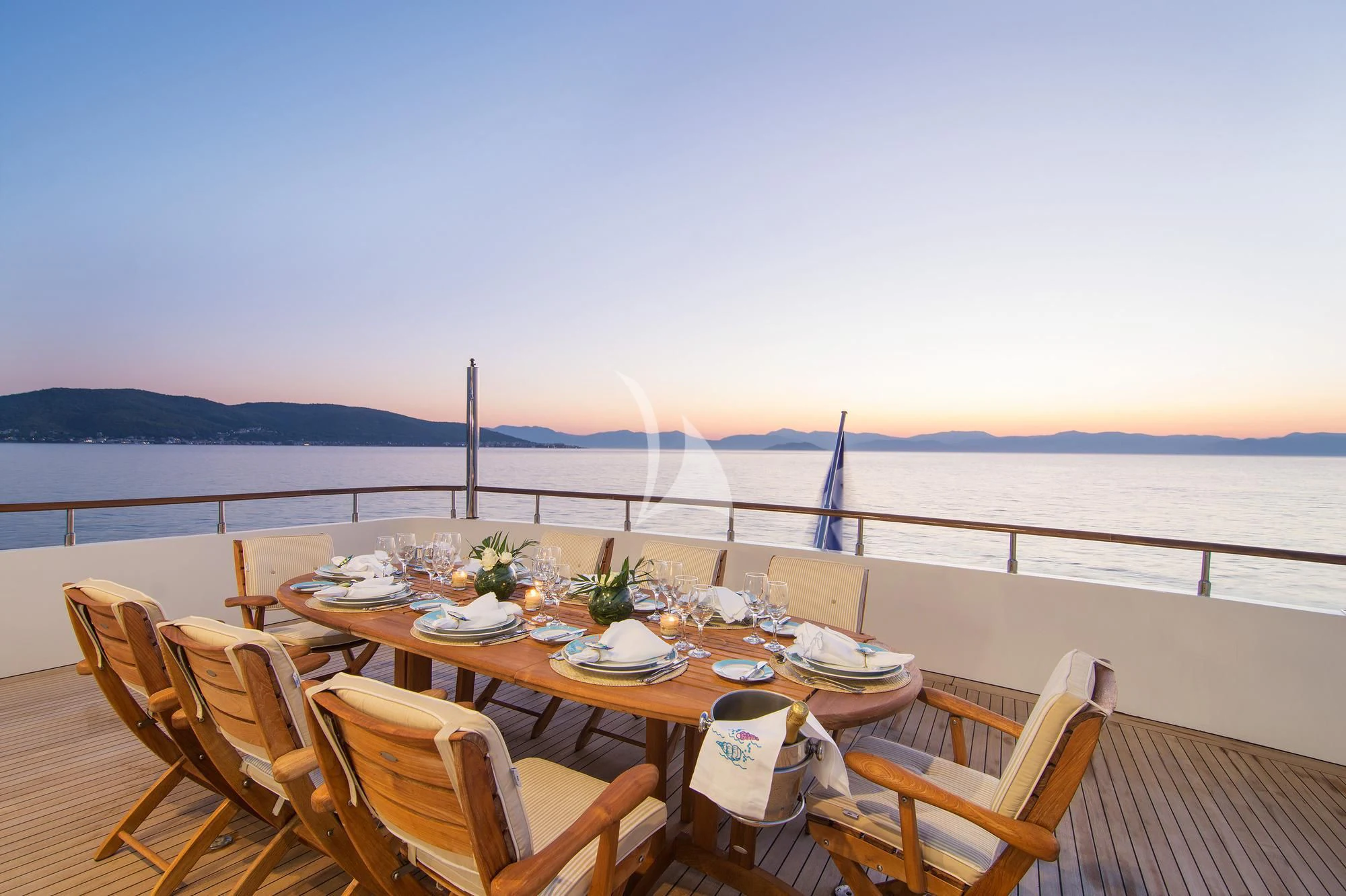 a table set for a meal on a deck overlooking the ocean aboard BELLA STELLA Yacht for Charter