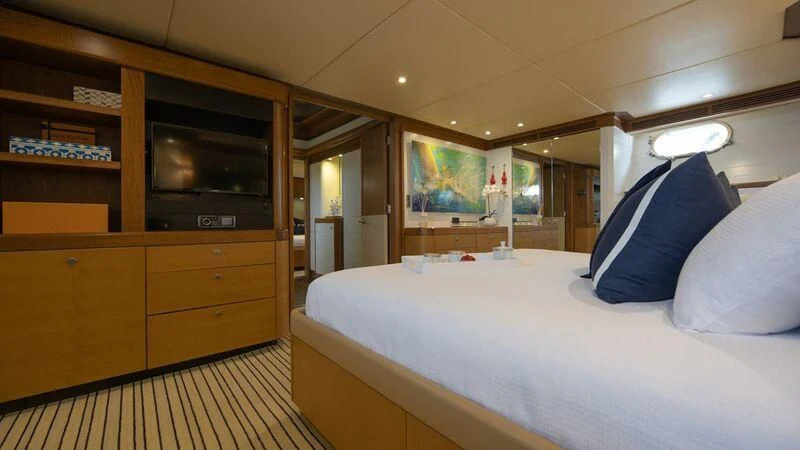 a room with a bed and a television aboard PIPELINER Yacht for Sale