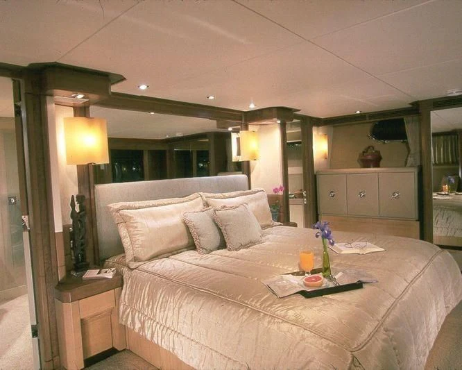 a bed with a white comforter and pillows aboard PIPELINER Yacht for Sale