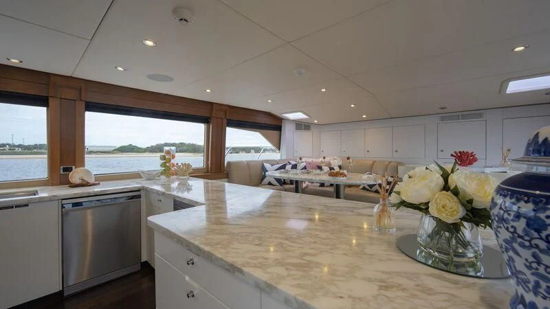 a kitchen with white cabinets and a large window aboard PIPELINER Yacht for Sale